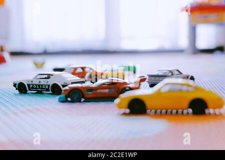 Giocattoli colorati piccoli Hot Wheels automobili di Mattel in stanza dei bambini tappetino di gioco Foto Stock
