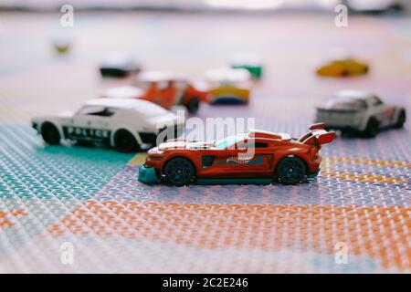 Giocattoli colorati piccoli Hot Wheels automobili di Mattel in stanza dei bambini tappetino di gioco Foto Stock