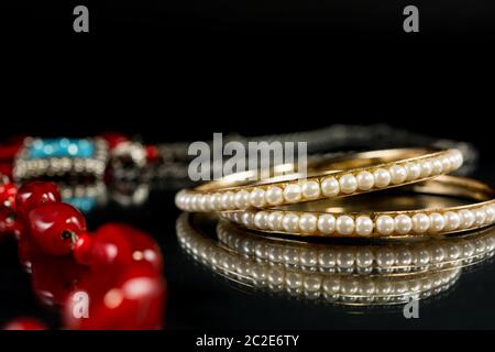 Elegante bracciale perla e gioielli su sfondo nero con bello riflessione Foto Stock