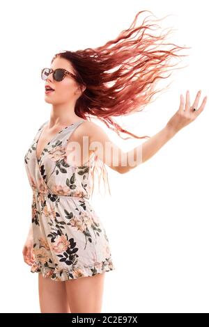 Ritratto di una giovane e bella ragazza indossando occhiali da sole, saltare e giocare con i suoi capelli, isolato su sfondo bianco. Foto Stock