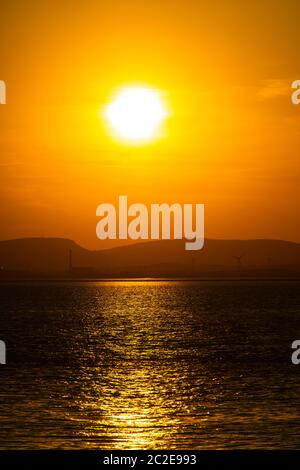 Il sole tramonta su Portishead e sull'estuario del Severn con la costa gallese in lontananza. Foto Stock