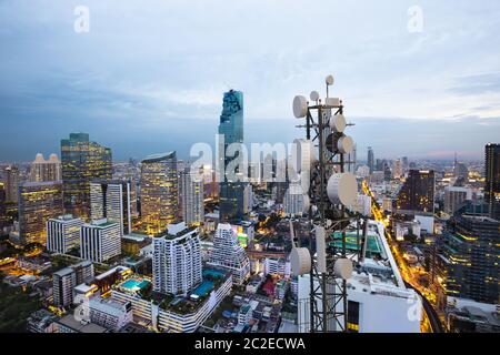 Torre di telecomunicazione con antenna di rete cellulare 5G su sfondo urbano Foto Stock