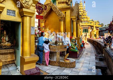 La gente birmana che fa il bagno del Buddha alla pagoda di Shwedagon, Yangon, Myanmar. Foto Stock