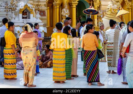 La gente locale guarda UNA cerimonia di Noviziazione/Shinbyu alla Pagoda Shwedagon, Yangon, Myanmar. Foto Stock