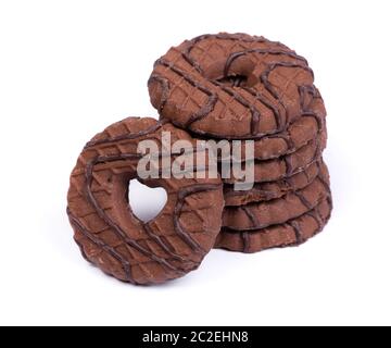 Un mucchio di biscotti rotondi al cioccolato con un foro a forma di cuore isolato su sfondo bianco Foto Stock