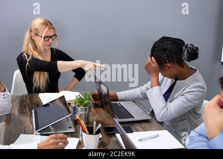 Angry Business donna femmina accusando il collega In riunione per errore di Business di Office Foto Stock