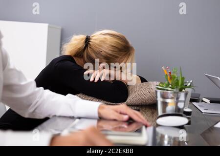 Bionda giovane imprenditrice dormendo mentre seduto al suo posto di lavoro Foto Stock