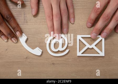 Persone azienda Email, Busta, telefono, le icone sulla Scrivania in legno Foto Stock
