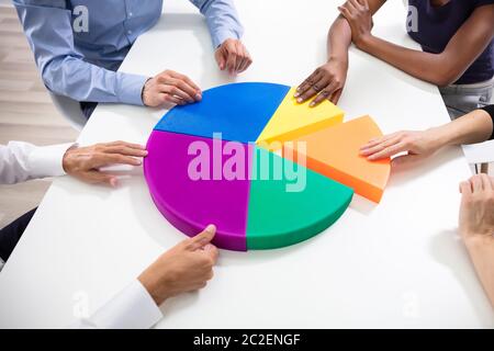 Elevato angolo di visione del business le mani il collegamento Multi pezzi colorati del grafico a torta Foto Stock