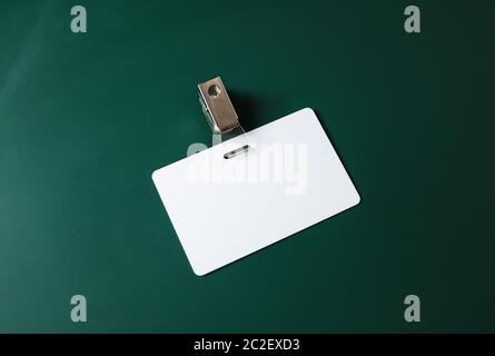 Blank ID card. In plastica bianca badge sulla lavagna verde dello sfondo. Copia spazio per il testo. Reattivo modello di progettazione. Foto Stock