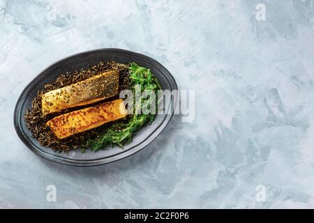 Salmone con semi di sesamo, alghe wakame e selvaggio riso nero, overhead shot con copyspace Foto Stock