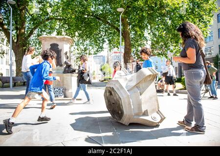 Una famiglia leggette la targa sulla base rotta il giorno dopo la deposizione della statua di Edward Colston a Bristol - 8 giugno 2020 Foto Stock