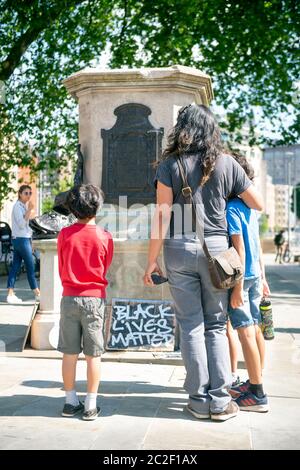 Una famiglia al basamento rotto nel luogo della statua rovesciata di Edward Colston a Bristol - 8 giugno 2020 Foto Stock