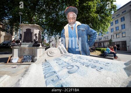 Lo scrittore e musicista Simbarashe Tongogara sormonda una sezione di zoccolo rotto nel sito della statua rovesciata di Edward Colston a Bristol - 8 giu Foto Stock