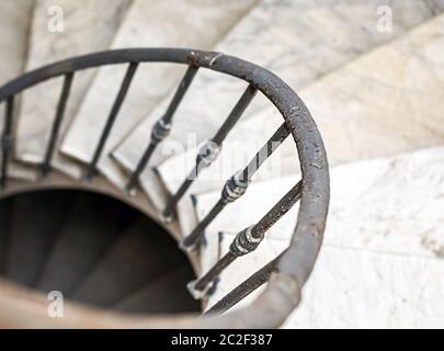 antica scala a chiocciola con scalini in marmo e corrimano in ferro battuto. Foto Stock