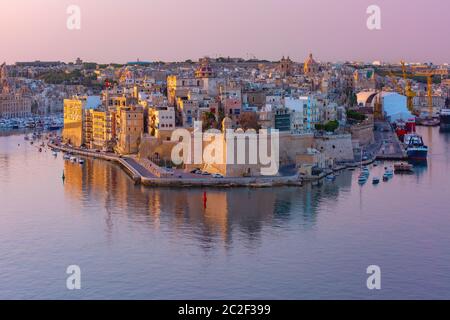 Vista aerea dello skyline dell'antico Forte Saint Michael della penisola di Senglea e del Grand Harbour visto dalla Valletta all'alba, Malta. Foto Stock