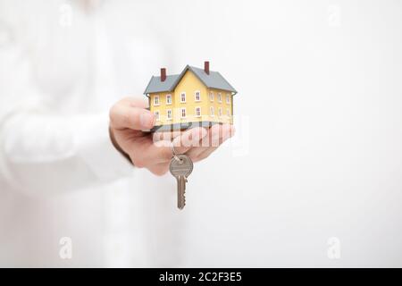 Piccola casa gialla miniaturizzato con chiavi in mano Foto Stock