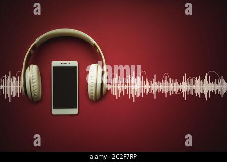 Moderno cellulare Bianco modello e cuffie su sfondo rosso gradiente con traccia Audio. Concetto musicale Foto Stock