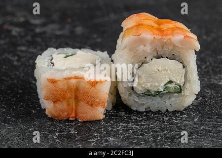 panini giapponesi di sushi con salmone, gamberi e anguilla affumicata con formaggio cremoso su piatto nero Foto Stock