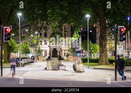 Bristol, Inghilterra, Regno Unito - 8 giugno 2020: Le persone che passano la base della statua rovesciata del commerciante di schiavi Edward Colston a Bristol leggono e lasciano i cartelli Foto Stock