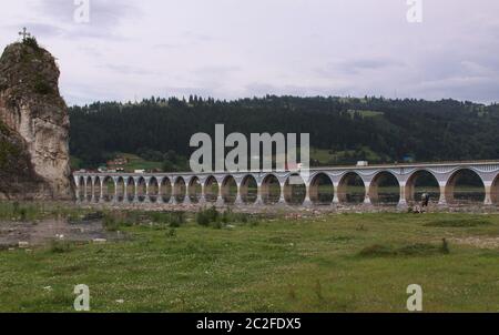 Acqua inquinata con detriti di bottiglie di plastica al ponte sul lago Bicaz sul fiume Bistrita, Romania. Distruzione ambientale causata dal lancio di rifiuti Foto Stock