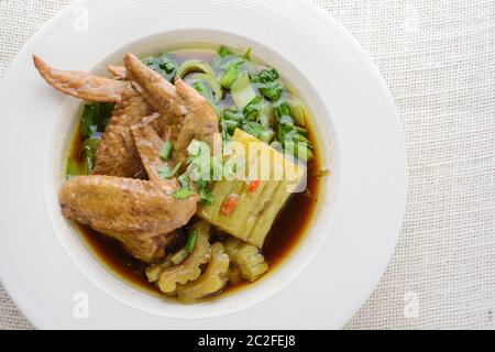 Ali di pollo brasate con il bitter Gourd Foto Stock