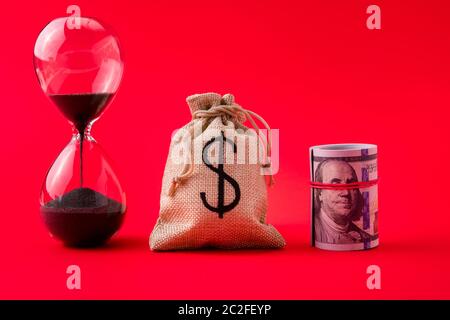 Vista ravvicinata delle azioni di gestione di moneybag tasso mazzo di dollari tempo condizione di servizio di orologio di sabbia mancanza di tempo mese anno isolato sopra Foto Stock