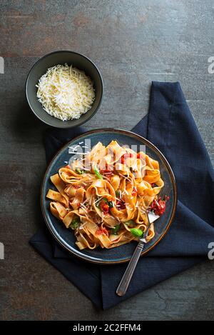 Gustosi piatti appetitosi in classico stile italiano la pasta con la salsa di pomodoro e formaggio parmigiano e basilico sulla piastra. Vista da sopra Foto Stock