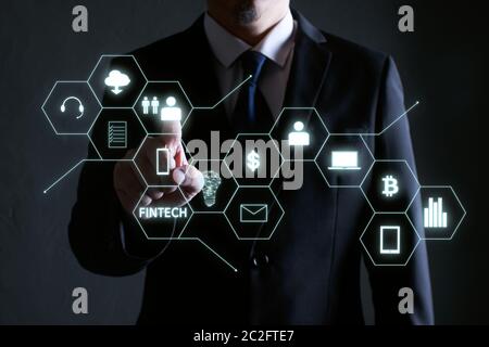 Uomo d'affari premendo l'icona del denaro su schermi virtuali, business, tecnologia e Internet concetto. Foto Stock
