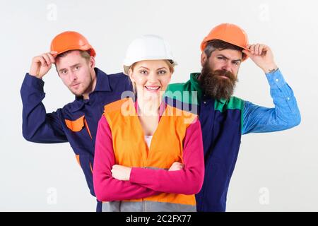 Il team di leadership e di concetto. Donna, leader in hard hat con la faccia felice sostare di fronte costruttori. Team di architetti, costruttori, operai spiata dietro al leader isolato sullo sfondo bianco. Foto Stock