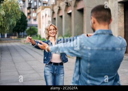 Felice incontro di due amanti che abbracciano la strada Foto Stock