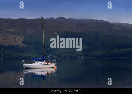 barca a vela ancorata nelle acque del Loch Lomond. Foto Stock