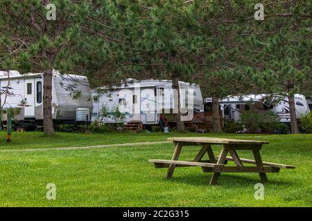 13 giugno 2020 - Frelighsburg, Quebec, Canada: Fila di roulotte stagionali RV Trailers campeggi su un campeggio e tavolo da picnic, parcheggio RV; caravanning Foto Stock