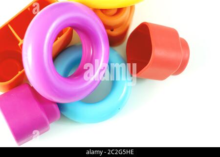 Anelli colorati in plastica e mattoni in gomma per i bambini. Foto Stock
