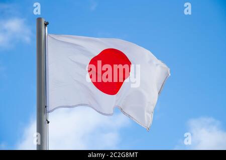Bandiera del Giappone è sventolata davanti al cielo blu Foto Stock