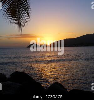 Tramonto incredibile a Curtain Bluff, Antigua, Caraibi - palme e calmo mare guardando il sole scendere nella vacanza migliore Foto Stock