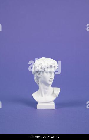 Una resina bianca busto su uno sfondo violetto. atmosfera pop. Colore minima ancora vita fotografia Foto Stock