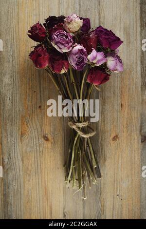 Bouquet di rose essiccato su un di legno Foto Stock