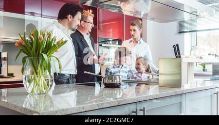Expert spiegando nuova cucina di famiglia in cerca di uno rivolto ad alcune interessanti caratteristiche del modello corrente Foto Stock