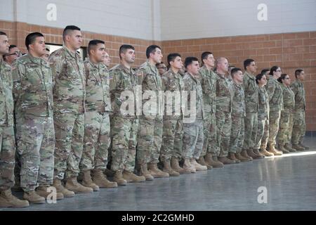 Weslaco, Texas 12 aprile 2018: Le truppe stanno all'attenzione di un'armeria della Guardia Nazionale nell'estremo sud del Texas mentre sentono le parole di incoraggiamento dal governatore Greg Abbott mentre si preparano per lo spiegamento al confine Texas-Messico. I soldati avranno un ruolo di sostegno con la pattuglia federale di frontiera e i soldati statali nel tentativo di rallentare l'immigrazione clandestina al confine meridionale degli Stati Uniti. ©Bob Daemmrich Foto Stock