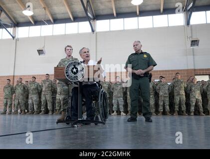 Weslaco, Texas USA, 12 aprile 2018: Texas Gov. Greg Abbott parla con le truppe della Guardia Nazionale presso l'armeria della Guardia Nazionale nell'estremo sud del Texas mentre si preparano per lo schieramento al vicino confine Texas-Messico. I soldati avranno un ruolo di sostegno con la pattuglia federale di frontiera e i soldati statali che tenteranno di arginare l'immigrazione clandestina al confine meridionale degli Stati Uniti. ©Bob Daemmrich Foto Stock