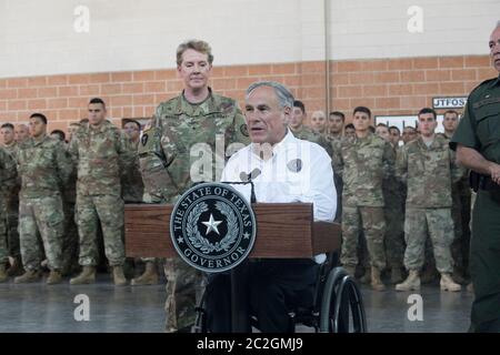 Weslaco, Texas USA, 12 aprile 2018: Texas Gov. Greg Abbott parla con le truppe della Guardia Nazionale presso l'armeria della Guardia Nazionale nell'estremo sud del Texas mentre si preparano per lo schieramento al vicino confine Texas-Messico. I soldati avranno un ruolo di sostegno con la pattuglia federale di frontiera e i soldati statali che tenteranno di arginare l'immigrazione clandestina al confine meridionale degli Stati Uniti. ©Bob Daemmrich Foto Stock