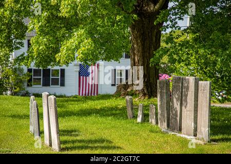 Una grande bandiera americana è appesa sulla porta di una vecchia casa storica a Phillipston, Massachusetts Foto Stock