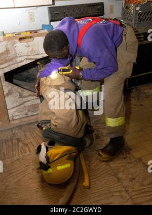 Austin Texas USA, febbraio 4 2014: Gli studenti della LBJ High School Fire Training Academy che indossano l'attrezzatura per l'affluenza si preparano per un esercizio di allenamento. Gli studenti laureati nel programma biennale avranno diritto alla certificazione EMT per i tecnici medici di emergenza e possiederanno competenze avanzate in materia di estinzione degli incendi. ©Bob Daemmrich Foto Stock