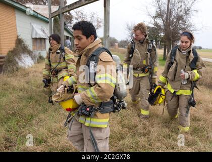 Austin Texas USA, febbraio 4 2014: Gli studenti della LBJ High School Fire Training Academy che indossano l'attrezzatura per l'affluenza si preparano per un esercizio di allenamento. Gli studenti laureati nel programma biennale avranno diritto alla certificazione EMT per i tecnici medici di emergenza e possiederanno competenze avanzate in materia di estinzione degli incendi. ©Bob Daemmrich Foto Stock