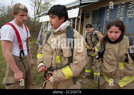 Austin Texas USA, febbraio 4 2014: Gli studenti della LBJ High School Fire Training Academy che indossano l'attrezzatura per l'affluenza si preparano per un esercizio di allenamento. Gli studenti laureati nel programma biennale avranno diritto alla certificazione EMT per i tecnici medici di emergenza e possiederanno competenze avanzate in materia di estinzione degli incendi. ©Bob Daemmrich Foto Stock