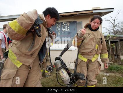 Austin Texas USA, febbraio 4 2014: Gli studenti della LBJ High School Fire Training Academy che indossano l'attrezzatura per l'affluenza si preparano per un esercizio di allenamento. Gli studenti laureati nel programma biennale avranno diritto alla certificazione EMT per i tecnici medici di emergenza e possiederanno competenze avanzate in materia di estinzione degli incendi. ©Bob Daemmrich Foto Stock