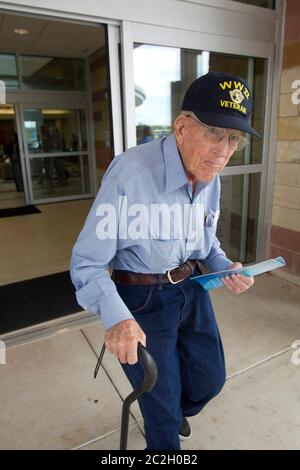 Austin, Texas USA, agosto 22 2013: Un veterano anziano della seconda guerra mondiale che cammina con una canna lascia l'area della lobby durante i festeggiamenti di apertura di una nuova Veterans Administration VA Outpatient Clinic nel sud-est di Austin. Con una superficie di circa 184.000 metri quadrati, è la più grande clinica ambulatoriale di Virginia indipendente della nazione, in sostituzione di un'altra struttura di Austin che invecchia. ©Bob Daemmrich Foto Stock