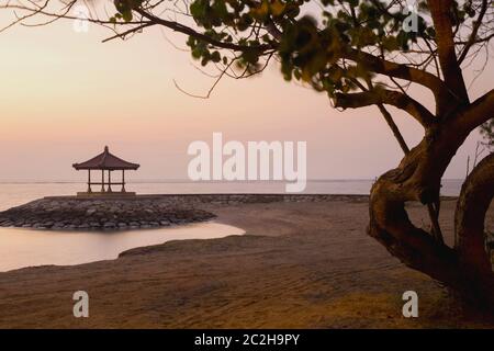 Paesaggio a Bali colorato alba sulla spiaggia Sanur, con rifugio e cielo rosa arancio, Indonesia beauti Foto Stock