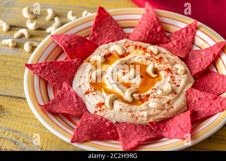 Hummus con tortilla chips sul tavolo di legno Foto Stock